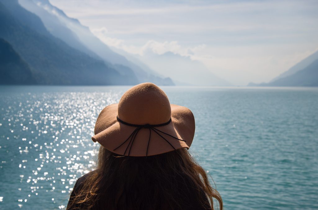 Me (a woman) looking out over a beautiful Swiss lake on my switzerland spring packing list guide for march, april and may