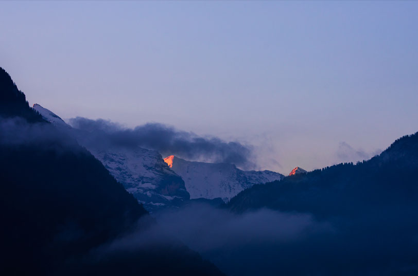 a dark, snowy moutain before sunrise for my switzerland winter packing list article